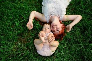 mãe abraça e brinca com sua filha de um ano enrolada em uma toalha após o banho. foto