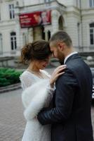 linda noiva linda e elegante noivo bonito, casal rústico em um campo de girassol se beijando foto