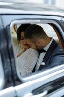 linda jovem noiva e noivo olhando de auto retrô foto