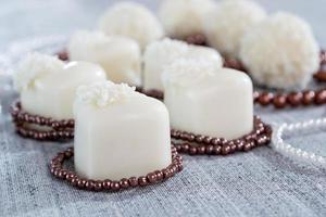 chocolates em forma de coração com balas de coco em flocos de miçangas foto