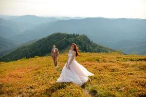 jovem casal apaixonado celebrando um casamento nas montanhas foto