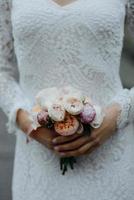 noiva com flores na mão ao ar livre. foto