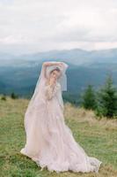 girando noiva segurando a saia véu do vestido de noiva na floresta de pinheiros foto