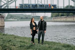 jovem casal apaixonado em pé na ponte suspensa da montanha abraçando olhando um para o outro sorrindo foto