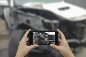 mão segurando o telefone inteligente tire uma foto no local de um acidente de carro, acidente de carro.