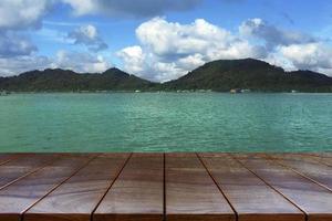 plataforma de espaço de mesa de madeira vazia e ilhas no fundo do mar e céu para montagem de exibição de produtos, mesa de madeira para colocação de produtos foto