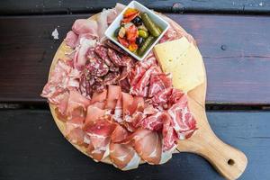 aperitivo italiano típico com salame, queijo e picles foto