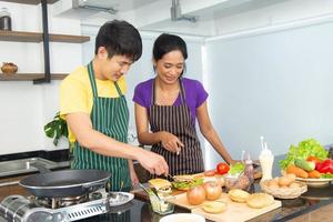 casal romântico e adorável asiático gosta e feliz cozinhando comida na cozinha foto