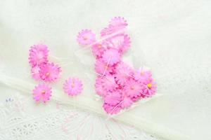 flores de papel artesanal em fundo de tecido branco, rosa e amarelo, decoração para cartão de convite.