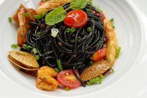 molho de espaguete preto, pimenta, frutos do mar. foto