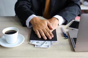 corrupção e suborno, empresário recebendo dinheiro em sua mesa de escritório foto