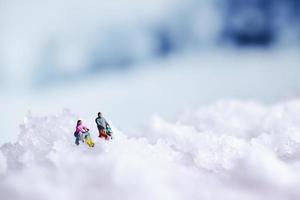 fundo de inverno com textura de neve e pessoas em miniatura foto