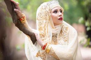 retrato de uma mulher .india linda garota indiana em joias e vestido de sari tradicional. retrato noiva muçulmana posando foto
