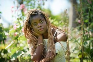 retrato de mulher jovem de pele negra com pose de penteado afro ao ar livre. foto