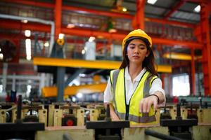 capataz de trabalhadora ou trabalhadora trabalha no local da fábrica, verifique a máquina ou os produtos no local. engenheiro ou técnico verificando material ou máquina na planta. industriais e fabris. foto