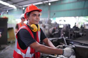 engenheiros de manutenção está trabalhando na frente do reparo automatizado de máquinas cnc em uma lista de verificação de manutenção na linha de produção. foto