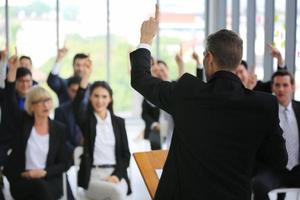 orador dando apresentação no salão. auditório ou sala de conferências. vista traseira de participantes não reconhecidos na audiência. evento de conferência científica, treinamento foto