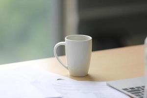 xícara de café branco na mesa de escritório foto