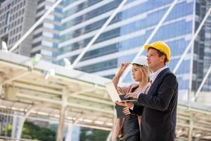 o engenheiro e a mulher de negócios verificando a área de transferência no prédio do canteiro de obras. o conceito de engenharia, construção, vida urbana e futuro. foto