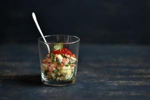 salada russa com caviar de salmão e vermelho na superfície azul foto