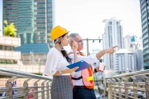 o engenheiro e a mulher de negócios verificando a área de transferência no prédio do canteiro de obras. o conceito de engenharia, construção, vida urbana e futuro. foto