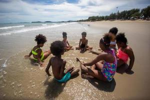 crianças brincando correndo na areia da praia foto