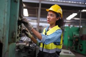 engenheiras de manutenção femininas estão trabalhando em frente ao reparo automatizado de máquinas cnc em uma lista de verificação de manutenção na linha de produção. foto