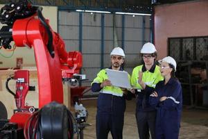 engenheiro industrial ou trabalhador usando um capacete em pé em uma fábrica industrial pesada. a manutenção procurando trabalhar em máquinas industriais e verificar a configuração do sistema de segurança na fábrica. foto