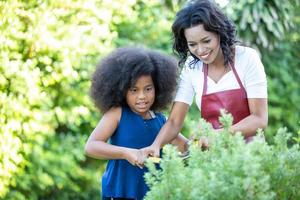retrato de família de raça mista feliz com crianças pré-escolares jardinagem em casa juntos foto