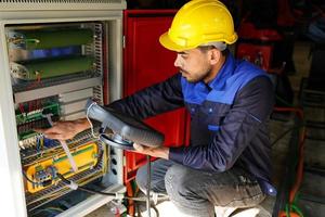 engenheiro verificando o painel de controle e ensinando novo braço robótico automático e máquina de controle operacional na fábrica. foto