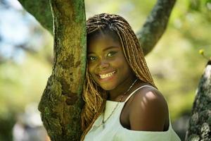 retrato de mulher jovem de pele negra com pose de penteado afro ao ar livre. foto