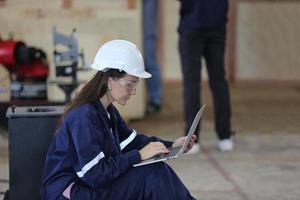 engenheiro industrial ou trabalhador usando um capacete em pé em uma fábrica industrial pesada. a manutenção procurando trabalhar em máquinas industriais e verificar a configuração do sistema de segurança na fábrica. foto