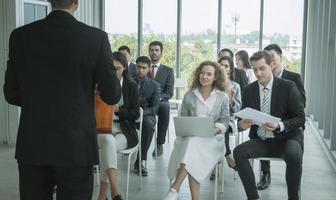 orador dando apresentação no salão. auditório ou sala de conferências. vista traseira de participantes não reconhecidos na audiência. evento de conferência científica, treinamento foto