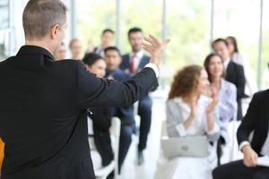 orador dando apresentação no salão. auditório ou sala de conferências. vista traseira de participantes não reconhecidos na audiência. evento de conferência científica, treinamento foto