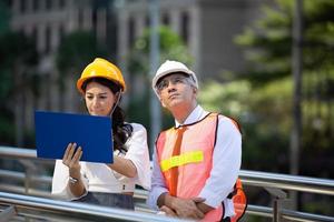 o engenheiro e a mulher de negócios verificando a área de transferência no prédio do canteiro de obras. o conceito de engenharia, construção, vida urbana e futuro. foto