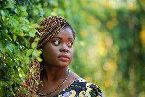 retrato de mulher jovem de pele negra com pose de penteado afro ao ar livre. foto