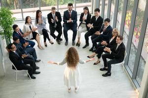 orador dando apresentação no salão. auditório ou sala de conferências. vista traseira de participantes não reconhecidos na audiência. evento de conferência científica, treinamento foto