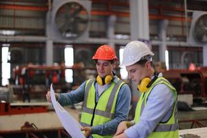 o capataz do trabalhador da indústria ou o trabalho do trabalhador no local da fábrica verificam a máquina ou os produtos no local. engenheiro ou técnico verificando material ou máquina na planta. industriais e fabris. foto