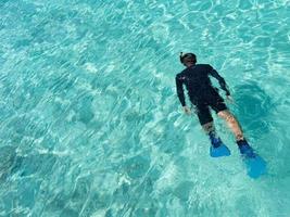 jovem mergulho em águas tropicais foto
