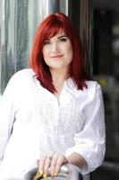 retrato urbano de mulher de cabelo vermelho, camisa branca foto