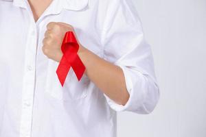 as mãos da menina segurando a fita vermelha de conscientização do câncer de mama e fita de conscientização da aids foto