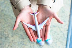 closeup mão segurando um modelo de avião no aeroporto