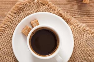 closeup vista de uma xícara de café, açúcar mascavo e grãos de café