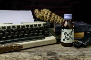 máquina de escrever com página de papel e veneno e arma. suspense de romance de escritor de conceito foto