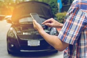 homem telefonando para ajudar com um carro quebrado foto