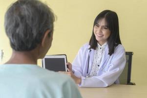 paciente masculino sênior asiático está consultando e visitando médico no hospital.. foto