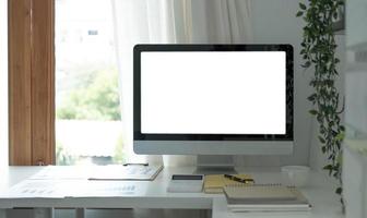 computador desktop de tela em branco em uma sala mínima de escritório com decoração e espaço de cópia foto