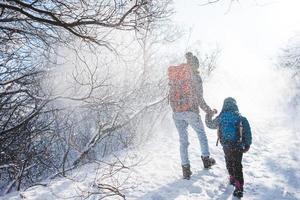 mulher com uma criança em uma caminhada de inverno nas montanhas. foto