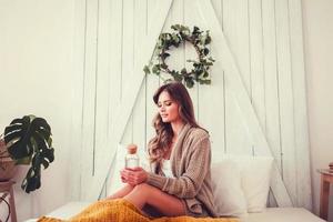 mulher jovem e bonita relaxando em casa foto