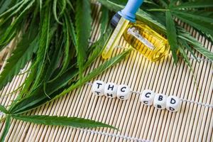 óleo de cannabis em produtos de garrafa em fundo de madeira - extrato de óleo de thc e cbd de maconha de folha de cannabis foto